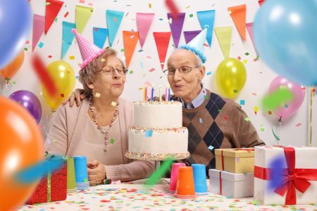 senior-couple-blowing-candles-on-a-birthday-cake